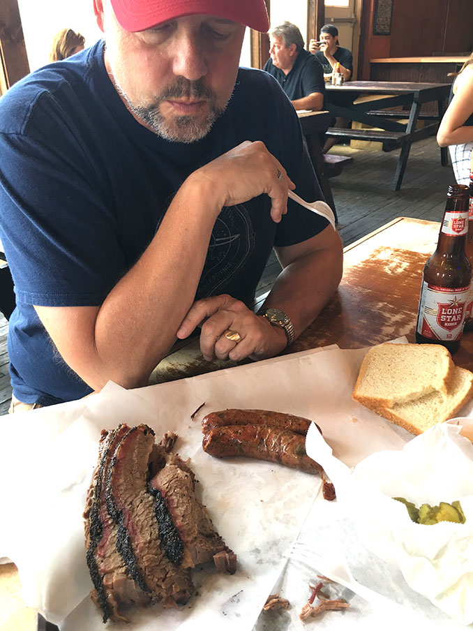 Richard sampling the sausage and brisket and Lone Star beer